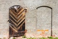 an old wooden door in a masonry and red brick wall Royalty Free Stock Photo