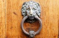 Old wooden door decorated with a lion head as knocker. Royalty Free Stock Photo