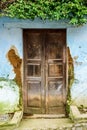 Old wooden door & dilapidated blue wall Royalty Free Stock Photo