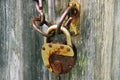 On the old wooden door, installed a rusty padlock. Wooden background. Royalty Free Stock Photo