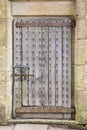 Old wooden door with iron studs and rusty hinges, bolted closed. Royalty Free Stock Photo