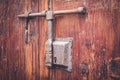 Old wooden door locked with metal bar / bolt - Royalty Free Stock Photo