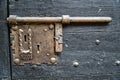 Old wooden door with metal knob and rusty medieval bolt. Royalty Free Stock Photo