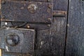 Old wooden door with metal knob and rusty medieval bolt. Royalty Free Stock Photo