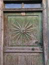 Old door with sun ornament and old wrought iron handle Royalty Free Stock Photo