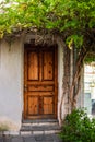 Old wooden door in an old stone wall. Street view of a simple, old-fashioned village house
