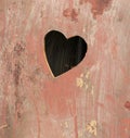 Old wooden door of an outhouse toilet with a heart shaped hole cut in Royalty Free Stock Photo