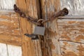 Old wooden door with a padlock, locked on the chain Royalty Free Stock Photo