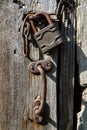 Old wooden door with padlock and rusty iron handle. Royalty Free Stock Photo