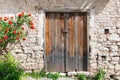 Old wooden door and rose bush at Laneia (Lania) village. Limassol District. Cyprus