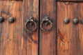 Old wooden door with round iron knockers