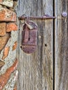 An old wooden door with a rusty iron lock and a padlock. Royalty Free Stock Photo