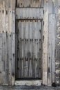 old wooden door with rusty tacks of a warehouse or a barn, old gate made of wood, light wooden planks on a rural barn gate, vintag Royalty Free Stock Photo