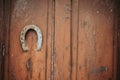 Old wooden door with a rusty upside-down horseshoe for good luck and increased wealth