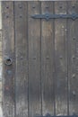 Old wooden door in the stone wall from medieval era. Vintage metal padlock on a wooden door. Royalty Free Stock Photo