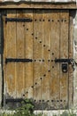 Old wooden door in stone wall with padlock Royalty Free Stock Photo