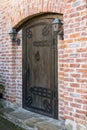 Vintage wooden door and knob in brick wall Royalty Free Stock Photo