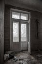 Old wooden door to a balcony in an abandoned house. Monochrome photo.