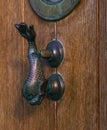 Old wooden door to house with a brass knocker in the shape of a Royalty Free Stock Photo