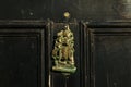 Old wooden door to house with brass knocker shaped sailing ship Royalty Free Stock Photo