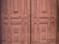 Old wooden door to the monastery in maroon color Royalty Free Stock Photo