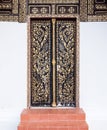 Old wooden door with the traditional Thai pattern. Royalty Free Stock Photo