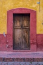 Old wooden door and wall on a house yellow and red in mexico village old town