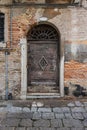 An old wooden door and wall weathered by age in Venice, Italy