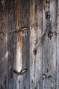 an old wooden door, weathered by the passage of time with an antique key inserted in the lock, worn wooden texture
