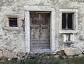 Old wooden door and window in a stone wall of an old house Royalty Free Stock Photo