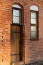 An old wooden door and windows in a red brick wall with stained glass Royalty Free Stock Photo