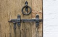 Old wooden door with wrought iron latch and handle in the form of a ring Royalty Free Stock Photo