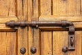 Old wooden door with wrought iron latch and studs Royalty Free Stock Photo