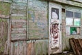 Old wooden doors on a collapsing building, a vintage barn, peeling paint, littered planks Royalty Free Stock Photo