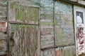 Old wooden doors on a collapsing building, a vintage barn, peeling paint, littered planks Royalty Free Stock Photo