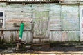 Old wooden doors on a collapsing building, a vintage barn, peeling paint, littered planks Royalty Free Stock Photo