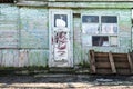 Old wooden doors on a collapsing building, a vintage barn, peeling paint, littered planks Royalty Free Stock Photo