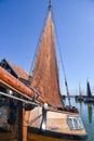 Old wooden Dutch fishing boat with brown sail in the harbor of Enkhuizen