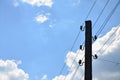 Old wooden electric pole for transmission of wired electricity on a background of a cloudy blue sky. Obsolete method of supplying Royalty Free Stock Photo