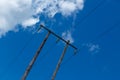 Old wooden electric post against blue sky and clouds Royalty Free Stock Photo