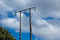 Old wooden electric post against blue sky and clouds Royalty Free Stock Photo