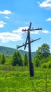 An old wooden electricity pole with insulators stands in the middle of a green field Royalty Free Stock Photo