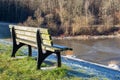 Old empty lakeside bench on a hill with view on a frozen lake in background Royalty Free Stock Photo