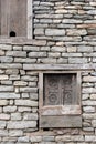 Old wooden ethnic Nepalese window in gray brick wall