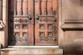 Old wooden exterior doors with decorative panels, brass doorknobs