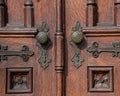 Old wooden exterior doors with decorative panels, brass doorknobs