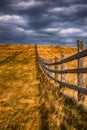 old wooden farme fence in a autumn rural landscape with dark clouds Royalty Free Stock Photo