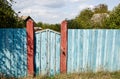 Old wooden fence against a blue sky with clouds on a sunny day Royalty Free Stock Photo