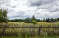 Old wooden fence against a blue sky with clouds on a sunny day Royalty Free Stock Photo