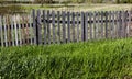 Old wooden fence against a blue sky with clouds on a sunny day Royalty Free Stock Photo